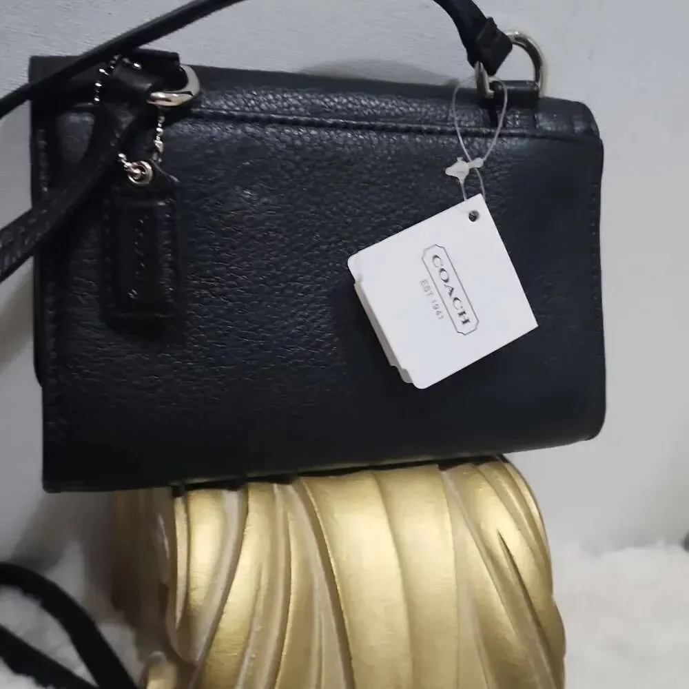 Coach Avery leather phone crossbody w/ a flap closure.